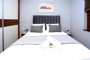a bedroom with a large white bed with two white socks at African Oasis Kenya in Somerset West +32 photos