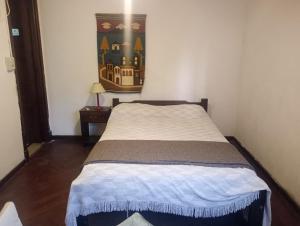een bed in een kamer met een schilderij aan de muur bij Alpino in Mar del Plata