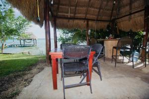 een rode tafel met stoelen onder een parasol op het strand bij Luigi’s Glamping in Bacalar