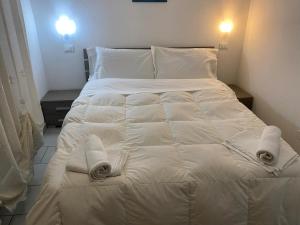 een bed met witte lakens en handdoeken erop bij Appartamento Premier in Gatteo a Mare