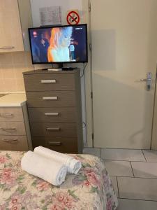 Schlafzimmer mit einem Bett, einem TV und einer Kommode in der Unterkunft Appartamento Premier in Gatteo a Mare