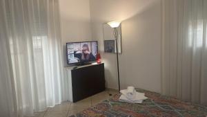 Zimmer mit einer Lampe und einem TV in einem Zimmer in der Unterkunft Appartamento Premier in Gatteo a Mare