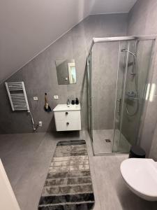 ein Badezimmer mit Dusche und Waschbecken in der Unterkunft ROOMS Park Mazeikiai in Mažeikiai