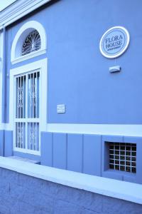 ein blaues Gebäude mit einem Fenster und einem Schild darauf in der Unterkunft Flora House Pompei Scafati in Scafati