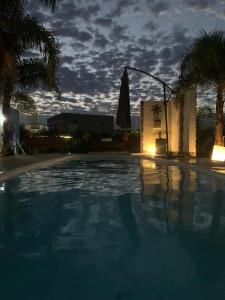 uma piscina à noite com um céu nublado em Chajari Suites em Chajarí