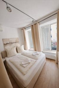 een wit bed in een kamer met 2 ramen bij Munich Premium Guesthouse-2 in München