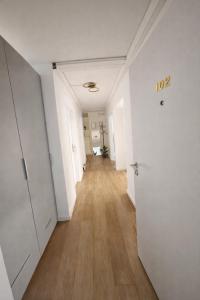 een lege hal in een appartement met witte muren en houten vloeren bij Munich Premium Guesthouse-2 in München +14 foto's
