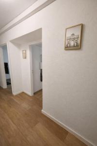 a hallway with white walls and a picture on a wall at Munich Premium Guesthouse-2 in Munich