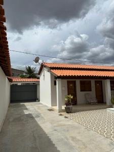 een wit huis met een oranje tegeldak bij Recanto Cangaço in Piranhas