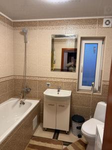a bathroom with a tub and a toilet and a sink at Floris in Myta