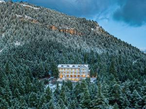 a large building in front of a mountain at MANNA, a Member of Design Hotels in Valtessiniko 