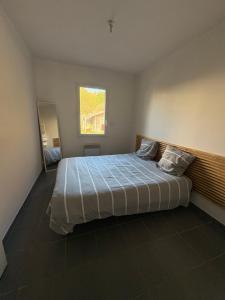 ein Schlafzimmer mit einem großen Bett mit Fenster in der Unterkunft Maison Carredas B in Bouliac