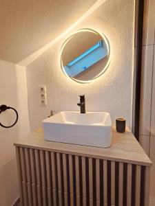 een wastafel met een spiegel op een aanrecht bij Stilvolles Apartment im Loft-Style & Klimaanlage in Plaidt +9 foto's