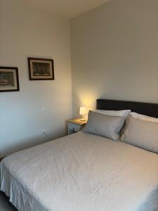 une chambre avec un lit blanc avec une lampe sur une table dans l'établissement Villa Pieri appartamento rosso, à Fauglia 12 autres photos