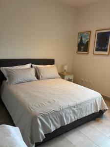 une chambre avec un grand lit avec des draps blancs dans l'établissement Villa Pieri appartamento rosso, à Fauglia