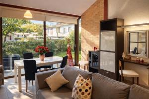 ein Wohnzimmer mit Sofa und Tisch in der Unterkunft Villa Pineta Grande in Lignano Sabbiadoro