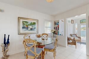 een eetkamer met een glazen tafel en stoelen bij Casa Del Mar in Key Colony Beach