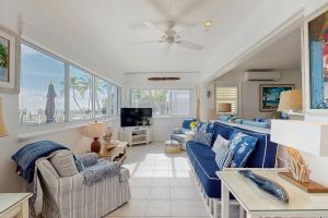 een woonkamer met blauwe banken en een tv bij Casa Del Mar in Key Colony Beach