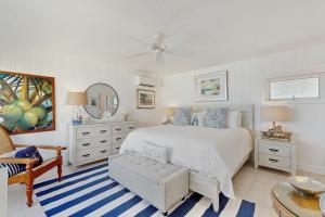 een witte slaapkamer met een bed en een stoel bij Casa Del Mar in Key Colony Beach