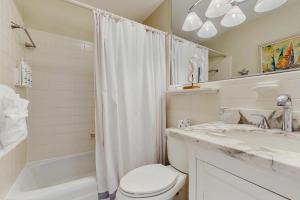 een witte badkamer met toilet en douche bij Casa Del Mar in Key Colony Beach +30 foto's
