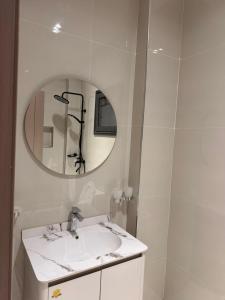 un bagno bianco con lavandino e specchio di Libellule a Dakar