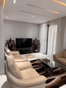 un soggiorno con mobili bianchi e tavolo in vetro di Libellule a Dakar