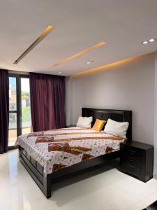 una camera da letto con un letto grande e una finestra di Libellule a Dakar