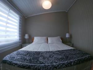 un letto in una camera con due lampade e una finestra di Ayekantun a Salto del Laja