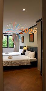 HY Local Budget Hotel - 5 mins walk to Hoi An Ancient Town في هوي ان: غرفة نوم بها سرير كبير مزين بلوحة "عام جديد سعيد".