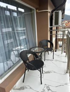 2 stoelen en een tafel op een balkon met sneeuw bij Nikos Apatament in Velingrad