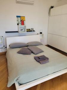 a bed with two pillows on it in a room at MINI House - 3 min dal GRA By followgreenhouserome in Rome