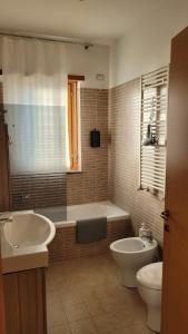 a bathroom with a tub and a toilet and a sink at MINI House - 3 min dal GRA By followgreenhouserome in Rome