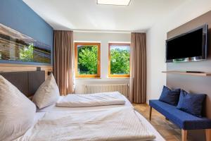 a bedroom with a bed and a tv and a chair at PAPPELHOF Landurlaub mit Panoramablick - Motorradunterkunft Fahrradunterkunft in Bad Bellingen