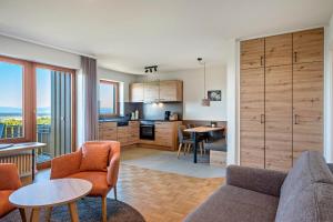 a kitchen and living room with a couch and a table at PAPPELHOF Landurlaub mit Panoramablick - Motorradunterkunft Fahrradunterkunft in Bad Bellingen