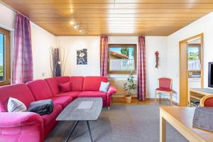 a living room with a red couch and a table at PAPPELHOF Landurlaub mit Panoramablick - Motorradunterkunft Fahrradunterkunft in Bad Bellingen