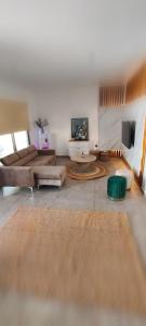 ein großes Wohnzimmer mit Sofas und Fernseher in der Unterkunft Light garden in Limassol