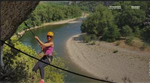 een vrouw aan een zipline boven een rivier bij Nora in Saint-Paul-Trois-Châteaux