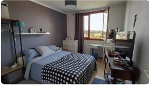 a bedroom with a bed and a desk and a window at Chambres d'hôtes in Saint-Paul-Trois-Châteaux