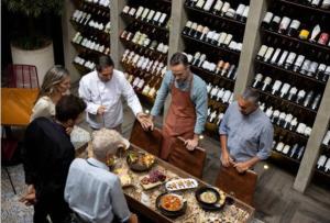 a group of people standing around a table in a wine store at Chambres d'hôtes in Saint-Paul-Trois-Châteaux