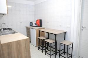 a kitchen with three bar stools and a sink at Iris House Pompei Scafati in Scafati