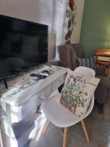 a living room with a desk and a chair with a pillow at Grace Guesthouse in Potchefstroom