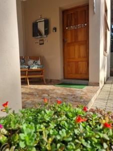 a front door of a house with a bench and flowers at Grace Guesthouse in Potchefstroom