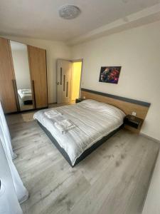 een slaapkamer met een groot bed en een houten vloer bij Nikos Apatament in Velingrad