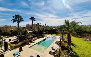 an overhead view of a swimming pool with palm trees at Villa Sbaa Marrakech in Marrakesh