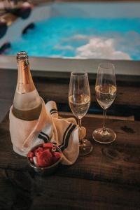 a bottle of wine and two glasses on a table at LARCADE Loft Industrial-Jacuzzi in Castillo de Bayuela