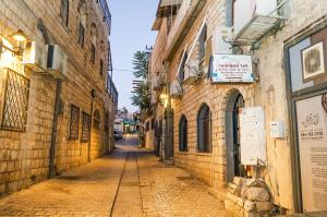 una strada vuota in un vicolo con edifici di הבית בעתיקה a Safed