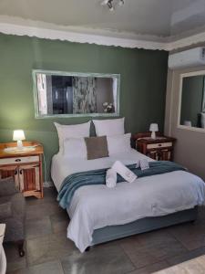 a bedroom with a large bed with two towels on it at Grace Guesthouse in Potchefstroom +153 photos