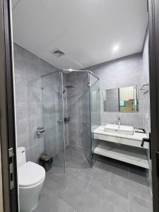 a bathroom with a shower and a toilet and a sink at Hanique Cafe and Stay in Hanoi