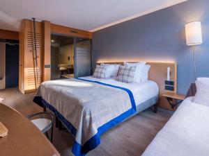 ein Hotelzimmer mit zwei Betten und einem Tisch in der Unterkunft Belambra Clubs Arc 1800 - Hôtel Du Golf in Arc 1800