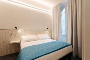 a small bedroom with a bed and a window at Le camere in città in La Spezia